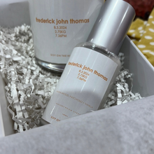 Load image into Gallery viewer, A personalised baby hamper featuring a hand-poured soy candle with the baby’s name, date, weight, and time of birth, a matching 100ml nursery spray, baby socks, and a knitted rattle, all enclosed in a magnetic close hamper box with a custom card and double-sided satin bow. Ships within 24 hours.