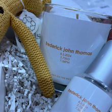 Load image into Gallery viewer, A personalised baby hamper featuring a hand-poured soy candle with the baby’s name, date, weight, and time of birth, a matching 100ml nursery spray, baby socks, and a knitted rattle, all enclosed in a magnetic close hamper box with a custom card and double-sided satin bow. Ships within 24 hours.