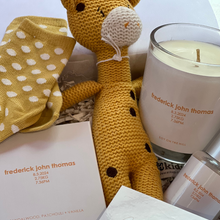 Load image into Gallery viewer, A personalised baby hamper featuring a hand-poured soy candle with the baby’s name, date, weight, and time of birth, a matching 100ml nursery spray, baby socks, and a knitted rattle, all enclosed in a magnetic close hamper box with a custom card and double-sided satin bow. Ships within 24 hours.